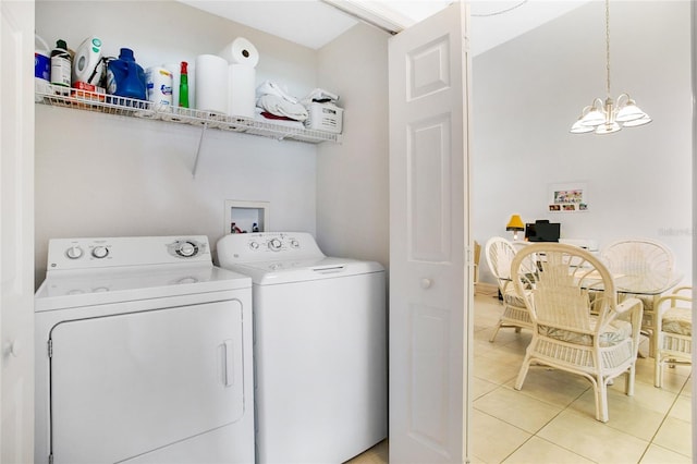 laundry area with a chandelier, washing machine and dryer, and light tile patterned flooring