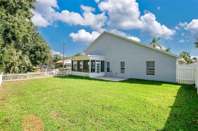 back of house featuring a sunroom, a patio area, and a yard