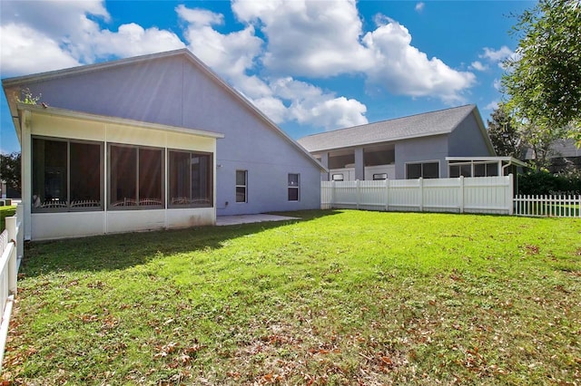 rear view of property featuring a sunroom and a yard