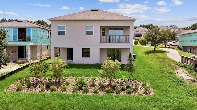 back of house with a yard and a balcony