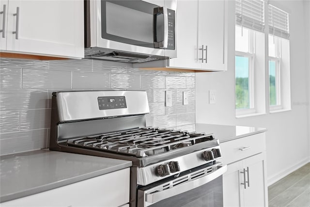 kitchen featuring appliances with stainless steel finishes, white cabinets, and backsplash