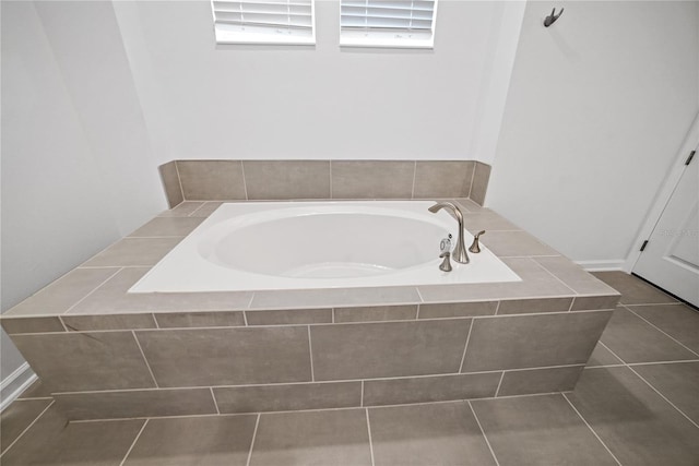 bathroom featuring a relaxing tiled tub and tile patterned flooring