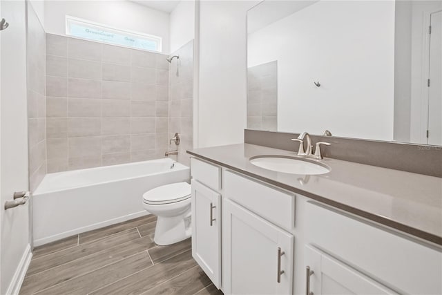 full bathroom with vanity, toilet, wood-type flooring, and tiled shower / bath