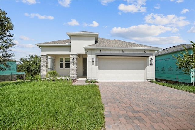 1180 Dora Parc Ln, Mount Dora, FL 32757 - prairie-style house with stucco siding, an attached garage, decorative driveway, a front yard, and roof with shingles