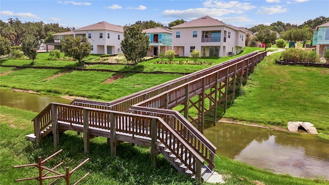 surrounding community featuring a water view and a yard