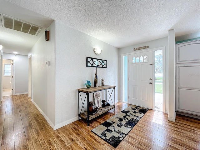 entryway featuring hardwood / wood-style floors and a textured ceiling