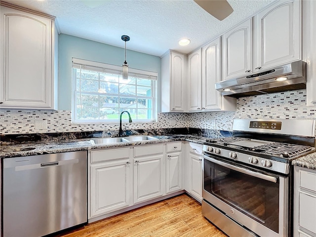 kitchen featuring stainless steel appliances, backsplash, sink, light wood-type flooring, and white cabinetry