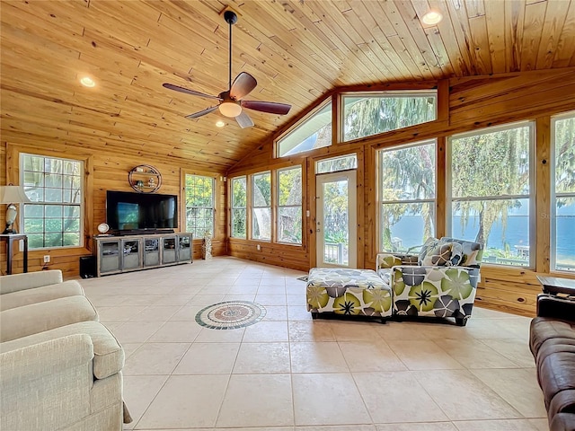 tiled living room featuring wood walls, wooden ceiling, and plenty of natural light