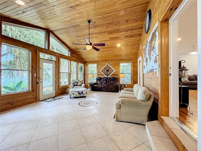 interior space with wood ceiling, a wealth of natural light, light tile patterned floors, and ceiling fan