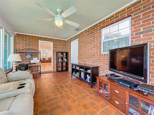 living room with a textured ceiling, a healthy amount of sunlight, brick wall, and ceiling fan