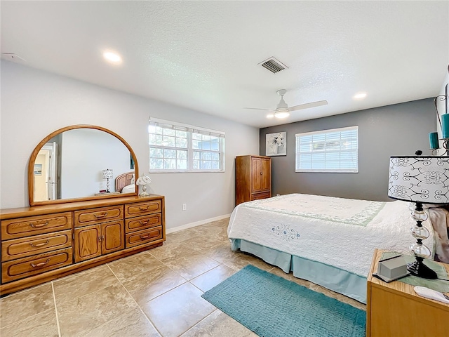 bedroom with ceiling fan, a textured ceiling, and multiple windows