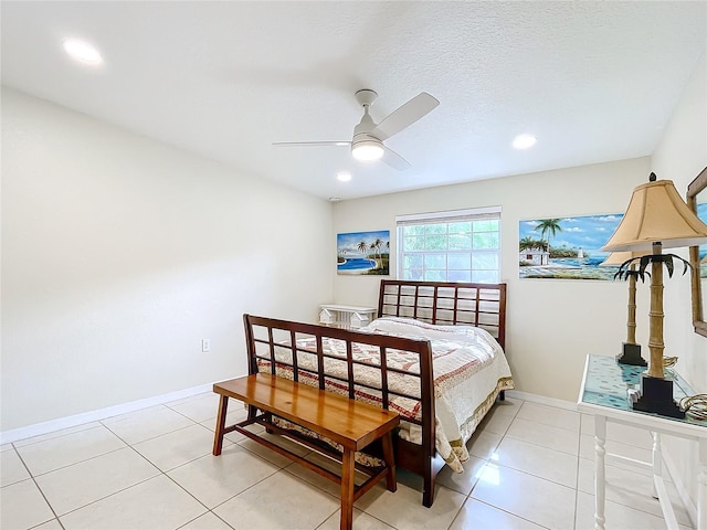 bedroom with a textured ceiling, light tile patterned floors, and ceiling fan