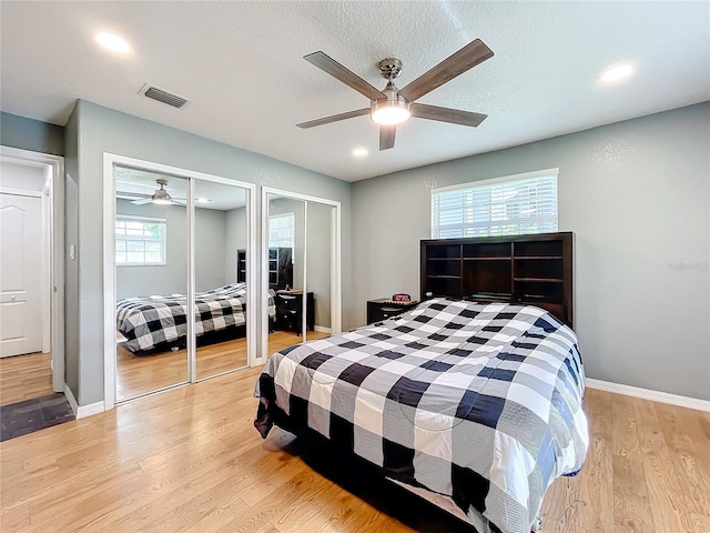 bedroom with light hardwood / wood-style flooring, multiple windows, and ceiling fan