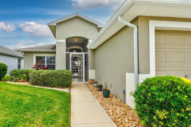 doorway to property featuring a lawn and a garage