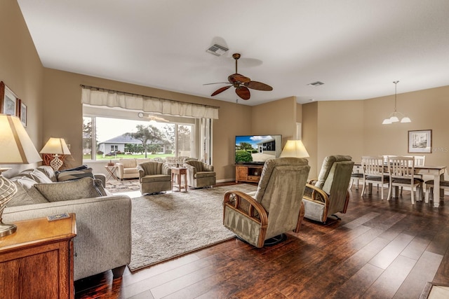 living room featuring ceiling fan with notable chandelier and dark hardwood / wood-style flooring