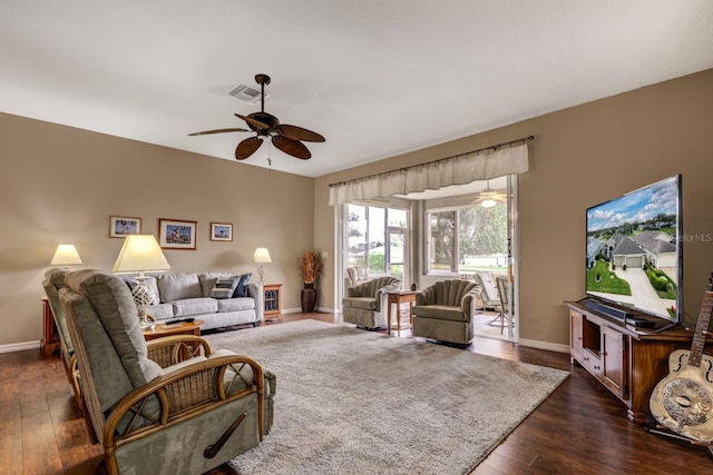 living room featuring dark wood-type flooring and ceiling fan