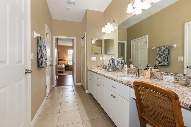 bathroom with vanity, an inviting chandelier, and tile patterned flooring