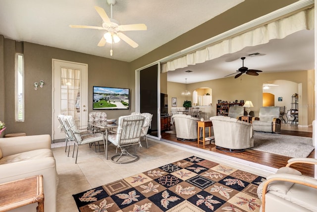 living room with light tile patterned floors and ceiling fan