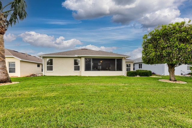 back of property featuring a yard and a sunroom