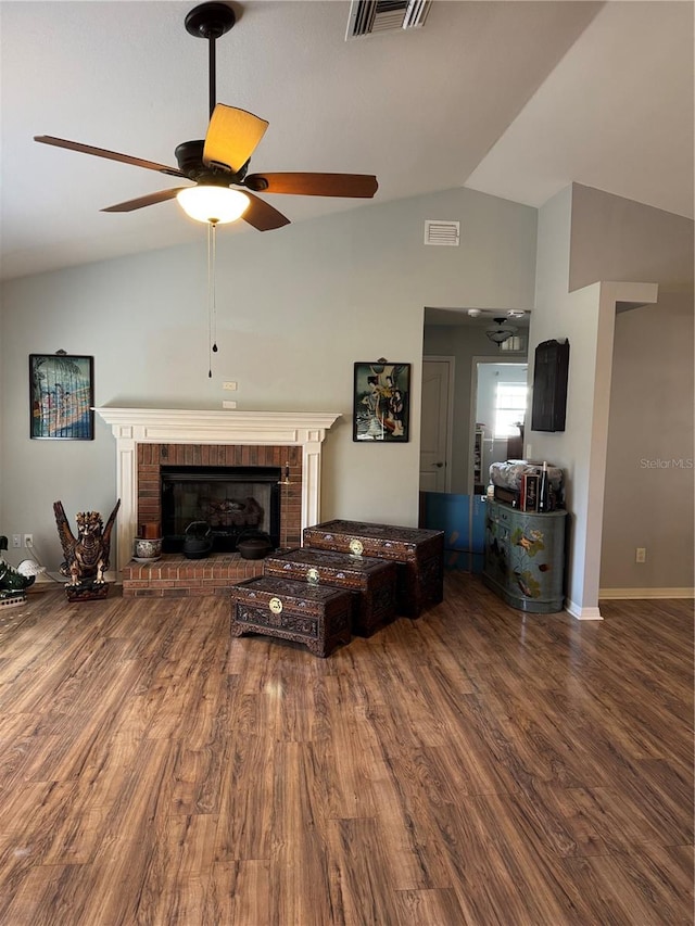 living room featuring hardwood / wood-style flooring, ceiling fan, a fireplace, and vaulted ceiling