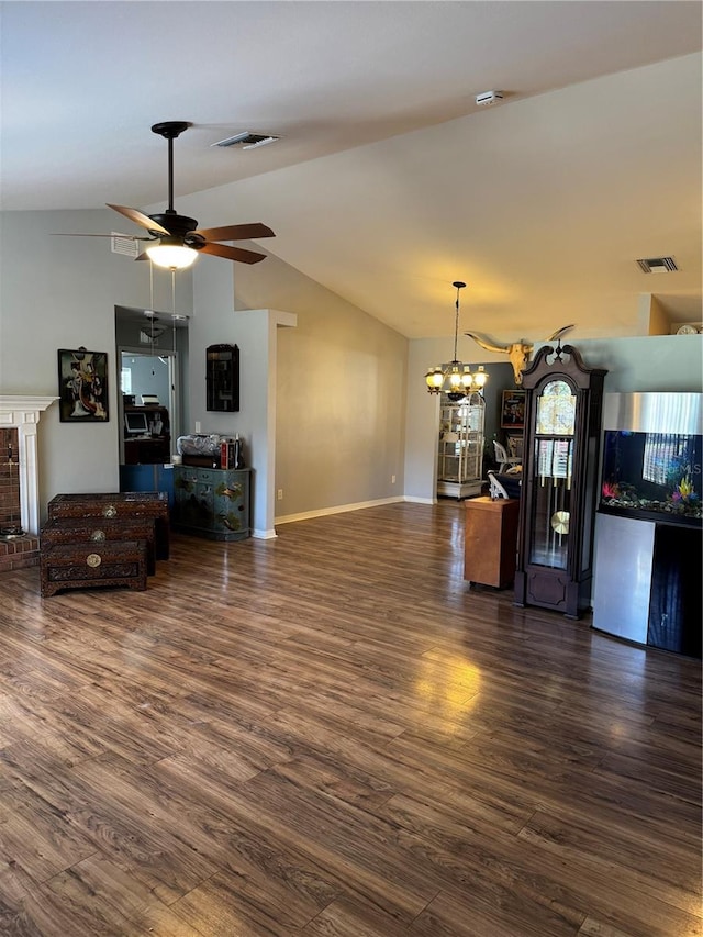 living room with vaulted ceiling, dark hardwood / wood-style floors, and ceiling fan with notable chandelier