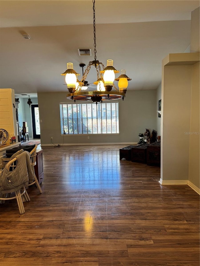 unfurnished dining area with dark hardwood / wood-style floors and an inviting chandelier