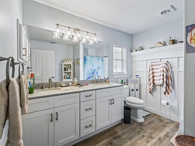 bathroom featuring vanity, toilet, wood-type flooring, and curtained shower