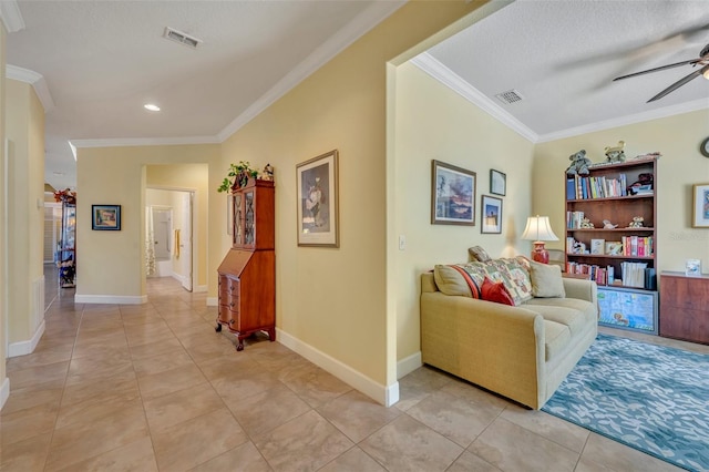 interior space featuring ceiling fan, ornamental molding, a textured ceiling, and light tile patterned floors