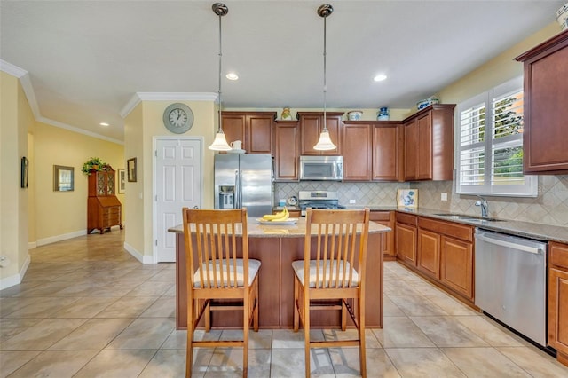 kitchen featuring hanging light fixtures, a breakfast bar area, a kitchen island, sink, and stainless steel appliances