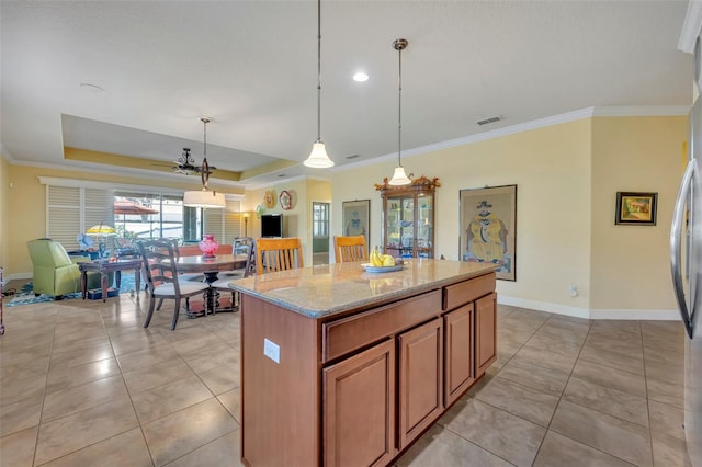 kitchen featuring ornamental molding, a kitchen island, light stone counters, and pendant lighting