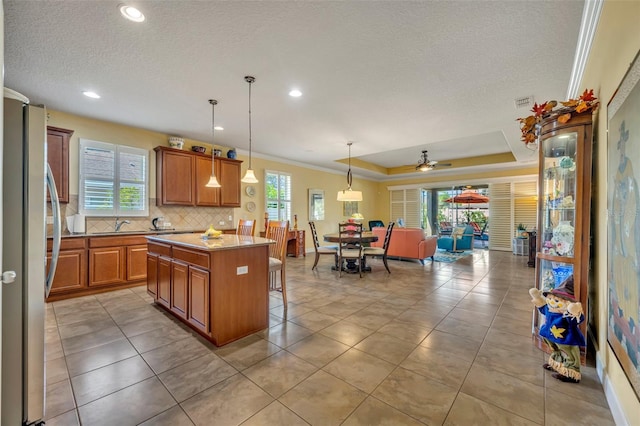 kitchen featuring a center island, a kitchen bar, pendant lighting, and a healthy amount of sunlight