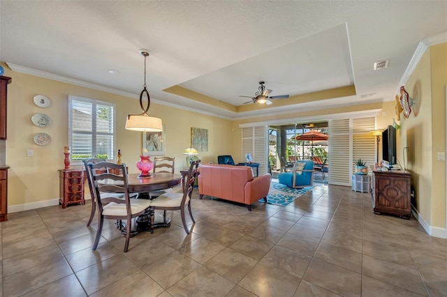 dining area featuring ornamental molding, a tray ceiling, and ceiling fan