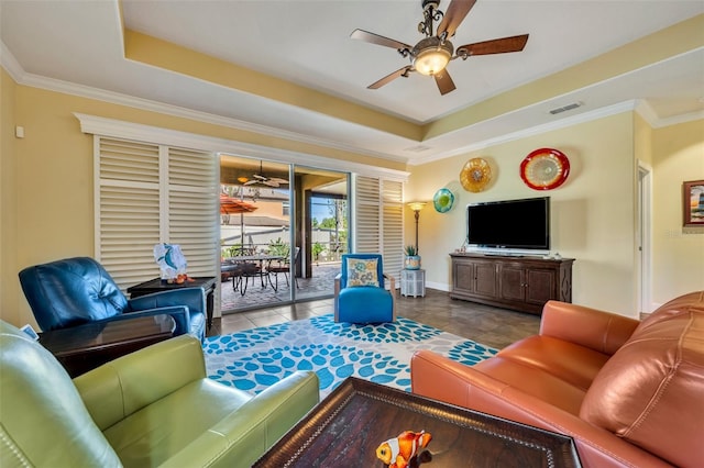 tiled living room featuring ceiling fan, crown molding, and a raised ceiling