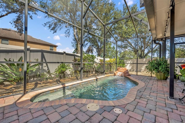 view of swimming pool featuring pool water feature, a patio, and a lanai