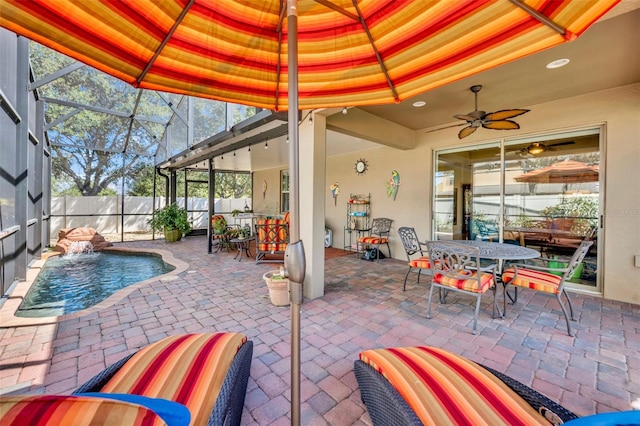 view of patio / terrace featuring a fenced in pool, pool water feature, glass enclosure, and ceiling fan