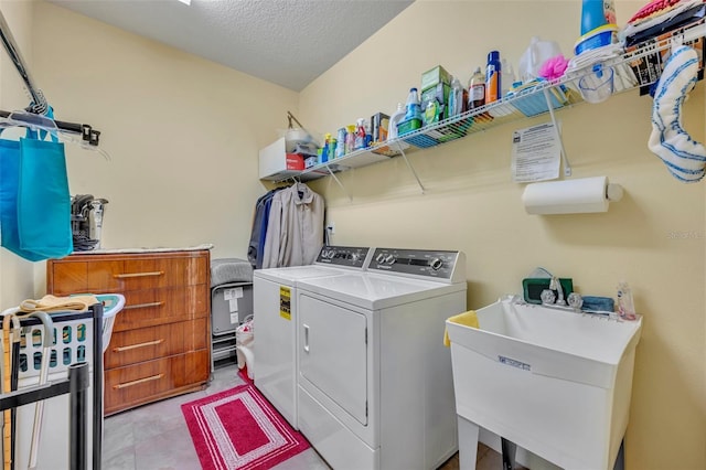 laundry area with sink, independent washer and dryer, and a textured ceiling