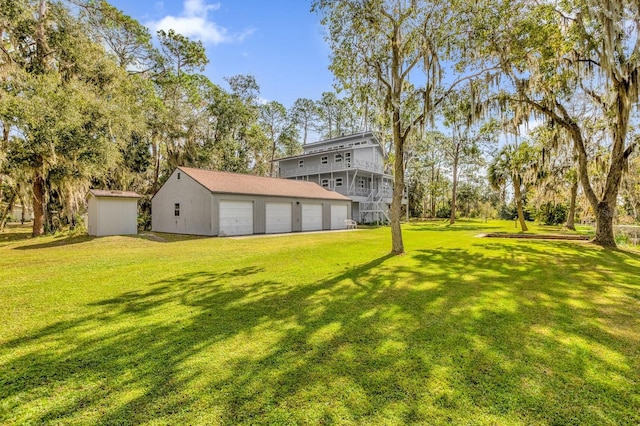 view of yard featuring a garage and an outdoor structure