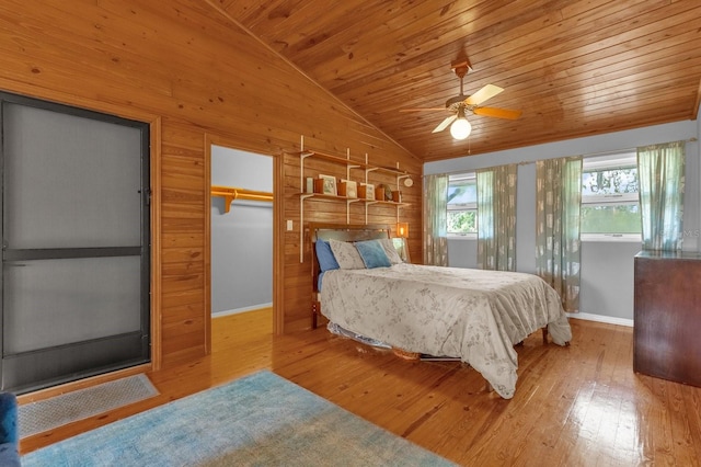 bedroom featuring wooden walls, wood ceiling, lofted ceiling, ceiling fan, and light hardwood / wood-style flooring