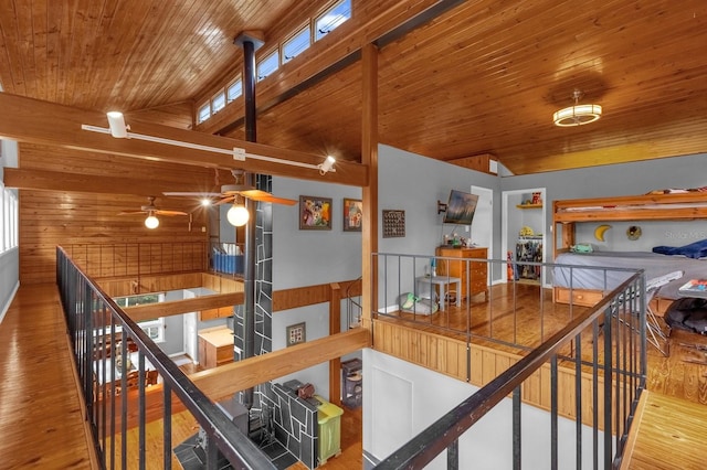 hallway featuring wood walls, high vaulted ceiling, wood-type flooring, and wooden ceiling