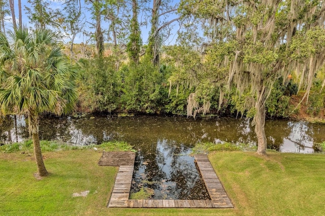 view of dock featuring a water view and a yard