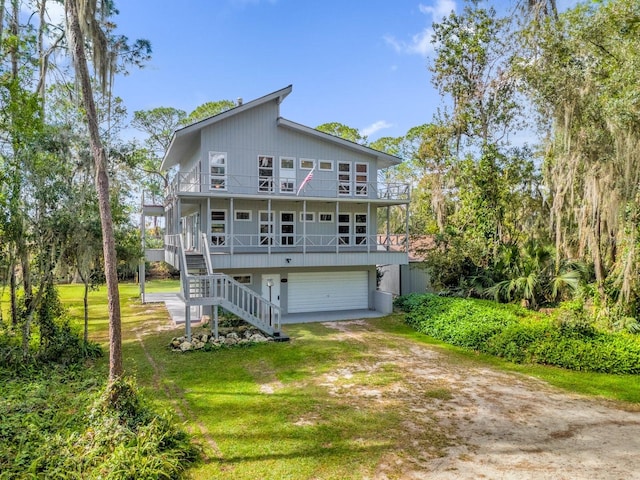 back of house with a lawn, a garage, and covered porch