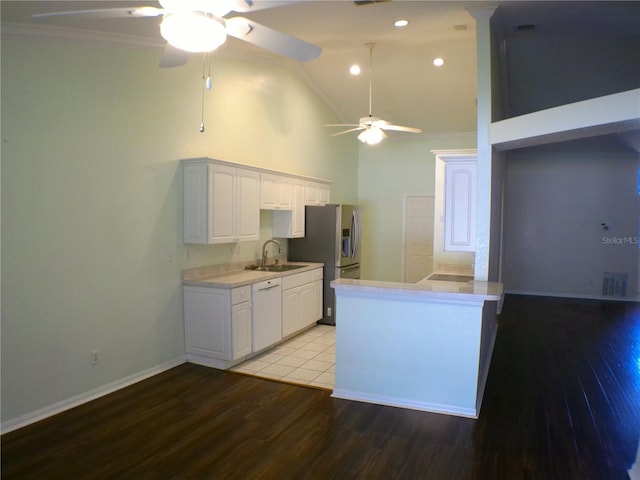 kitchen featuring dishwasher, sink, light wood-type flooring, kitchen peninsula, and white cabinets