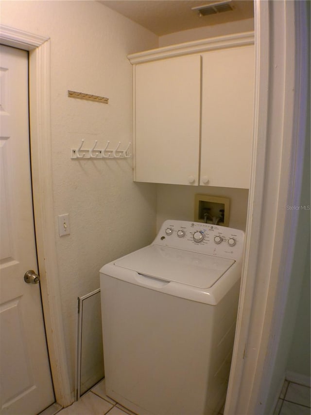 laundry room featuring light tile patterned floors, cabinets, and washer / clothes dryer