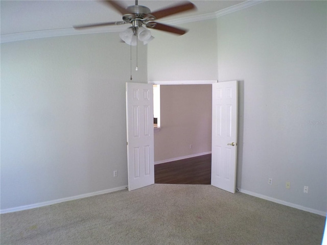 empty room featuring crown molding, dark colored carpet, and ceiling fan