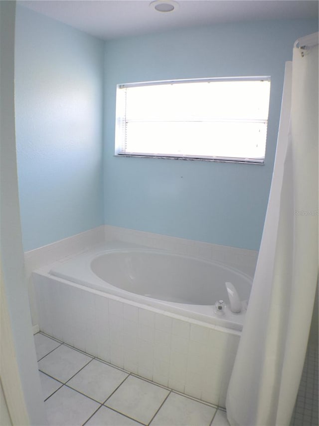 bathroom featuring tiled bath, tile patterned floors, and plenty of natural light