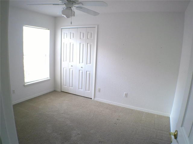 unfurnished bedroom with carpet floors, a closet, and ceiling fan