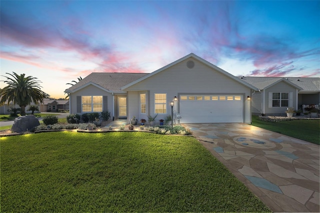 view of front of home with a garage and a lawn