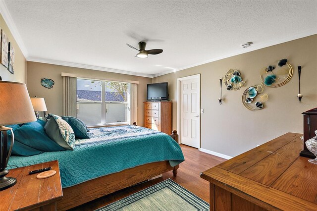 bedroom featuring crown molding, a textured ceiling, hardwood / wood-style flooring, and ceiling fan