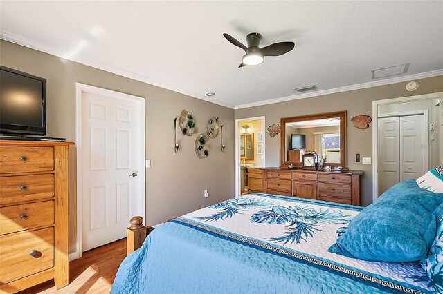 bedroom featuring ornamental molding, ensuite bath, light wood-type flooring, and ceiling fan