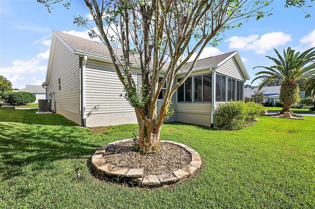 view of yard featuring central air condition unit and a sunroom